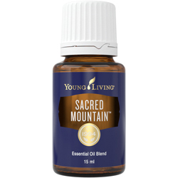 Small brown bottle of Young Living Sacred Mountain™ essential oil with a white lid and a periwinkle-colored label featuring a gold seal.