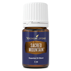 A small brown bottle of Young Living essential oil with a royal purple label and white writing that reads "Sacred Mountain."